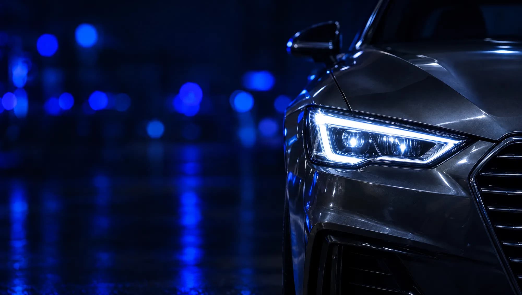 Faro de un carro de noche con luces azules.